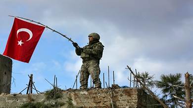 جندي تركي يرفع علم بلاده في شمال شرق عفرين السورية